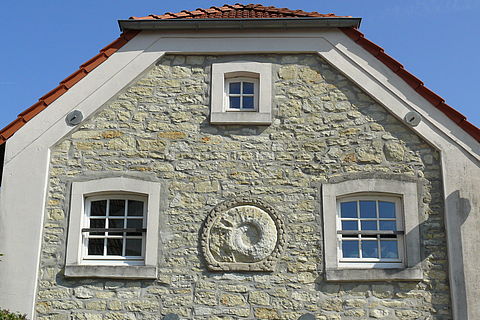 AWO-Hof: Fassade aus Bruchsteinen mit einem eingemauerten Ammoniten im Giebel.