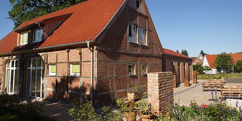 Blick über den Garten auf das Naturschutzzentrum im restaurierten und modernisierten Torhaus. 